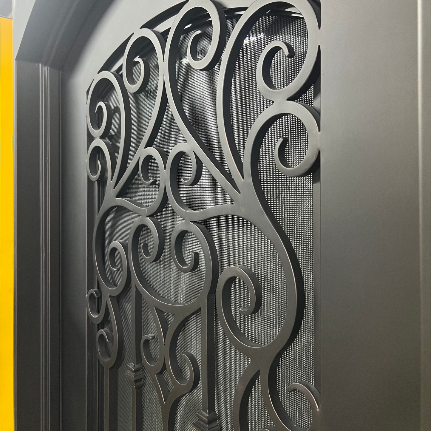 Decorative metal gate with intricate designs on a gray background