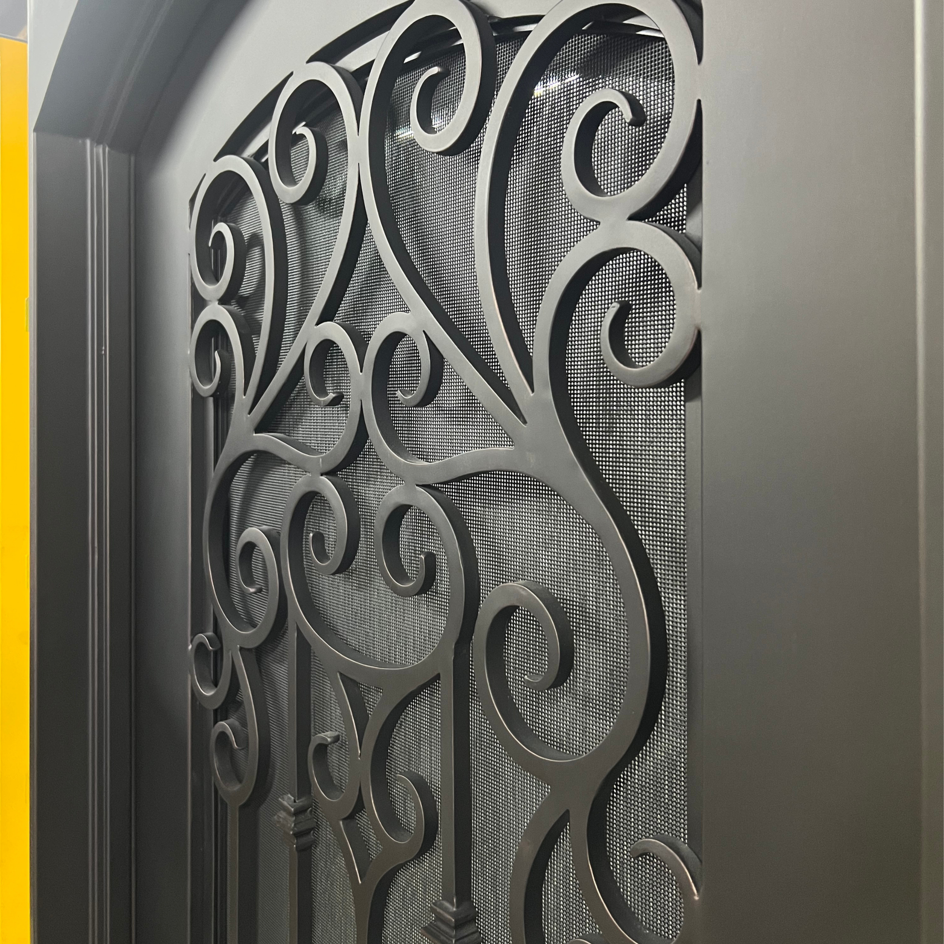 Decorative metal gate with intricate designs on a gray background