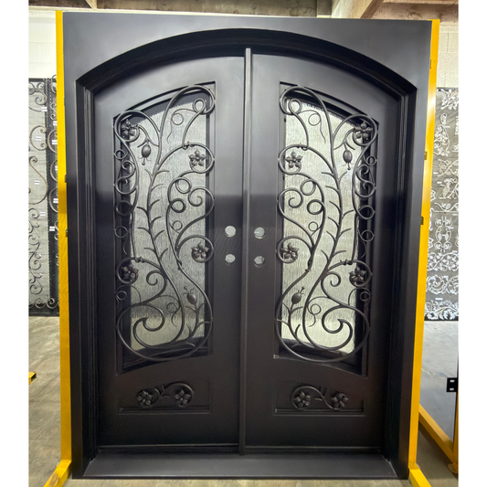 Decorative iron double door with floral arrangement on the left