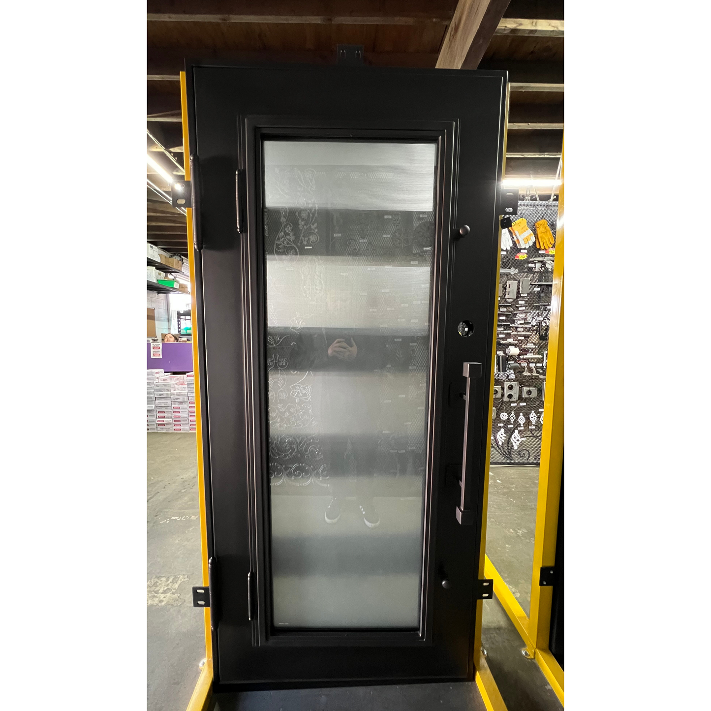 Black door with glass panel in a warehouse setting