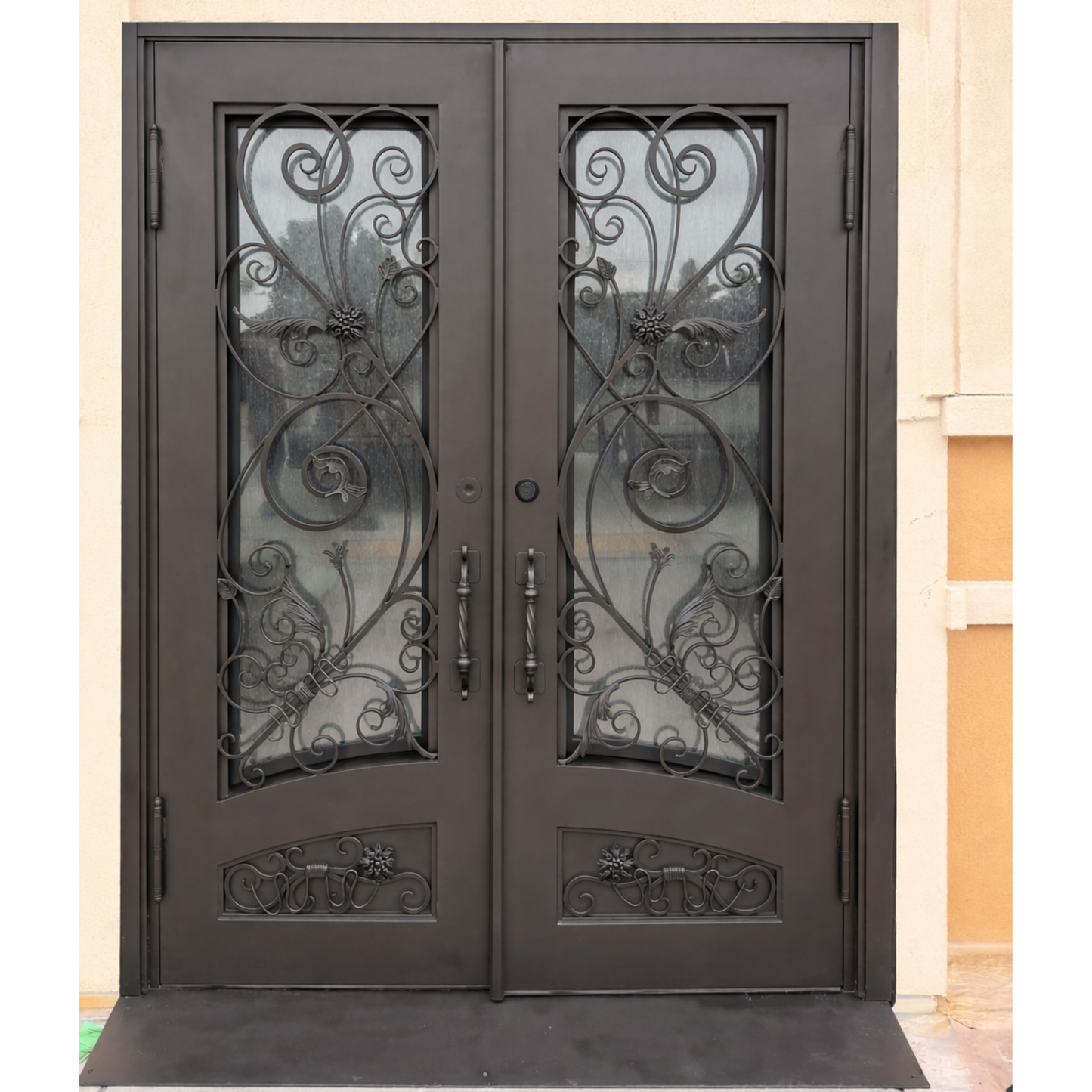 Decorative double doors with intricate iron work on a building exterior.