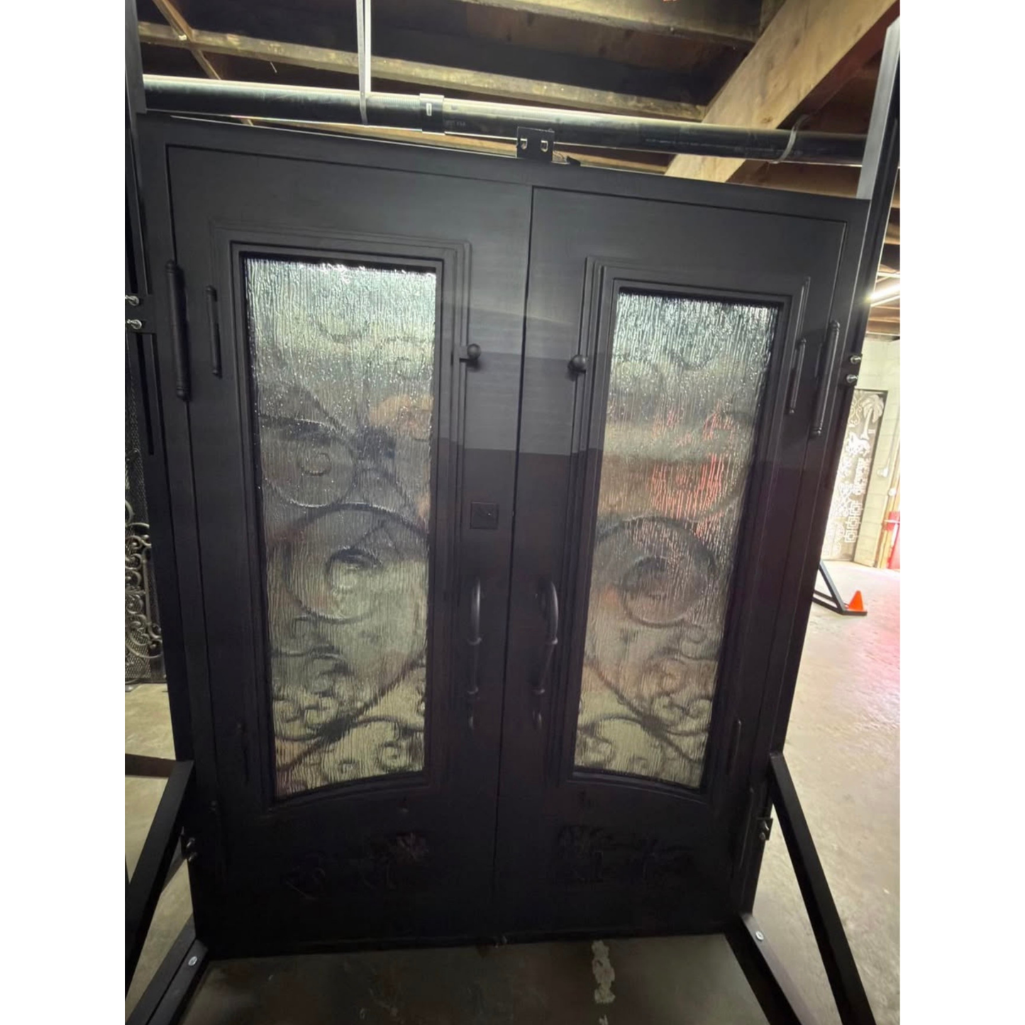 Decorative glass doors with intricate designs on a stand indoors.