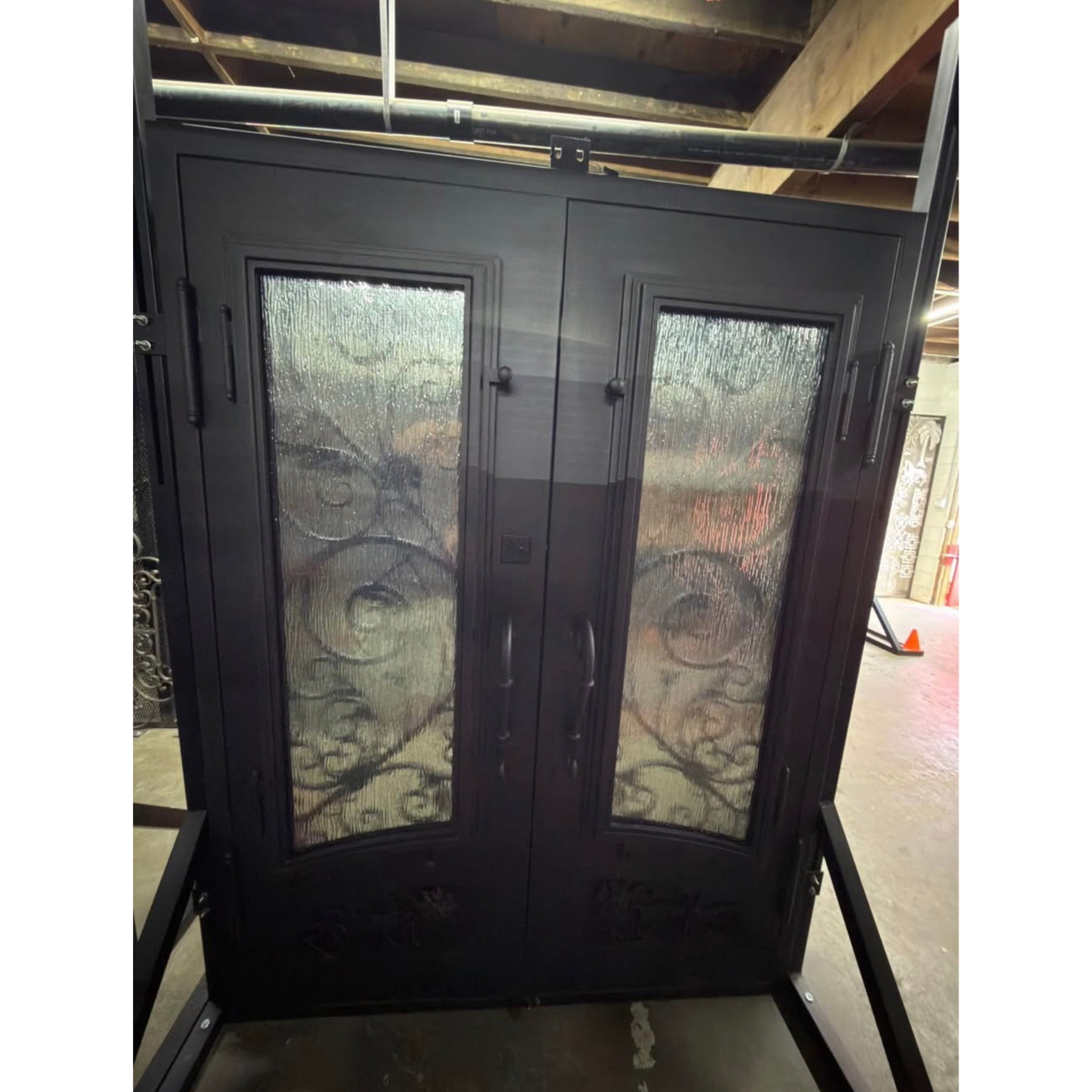 Decorative glass doors with intricate designs on a stand indoors.