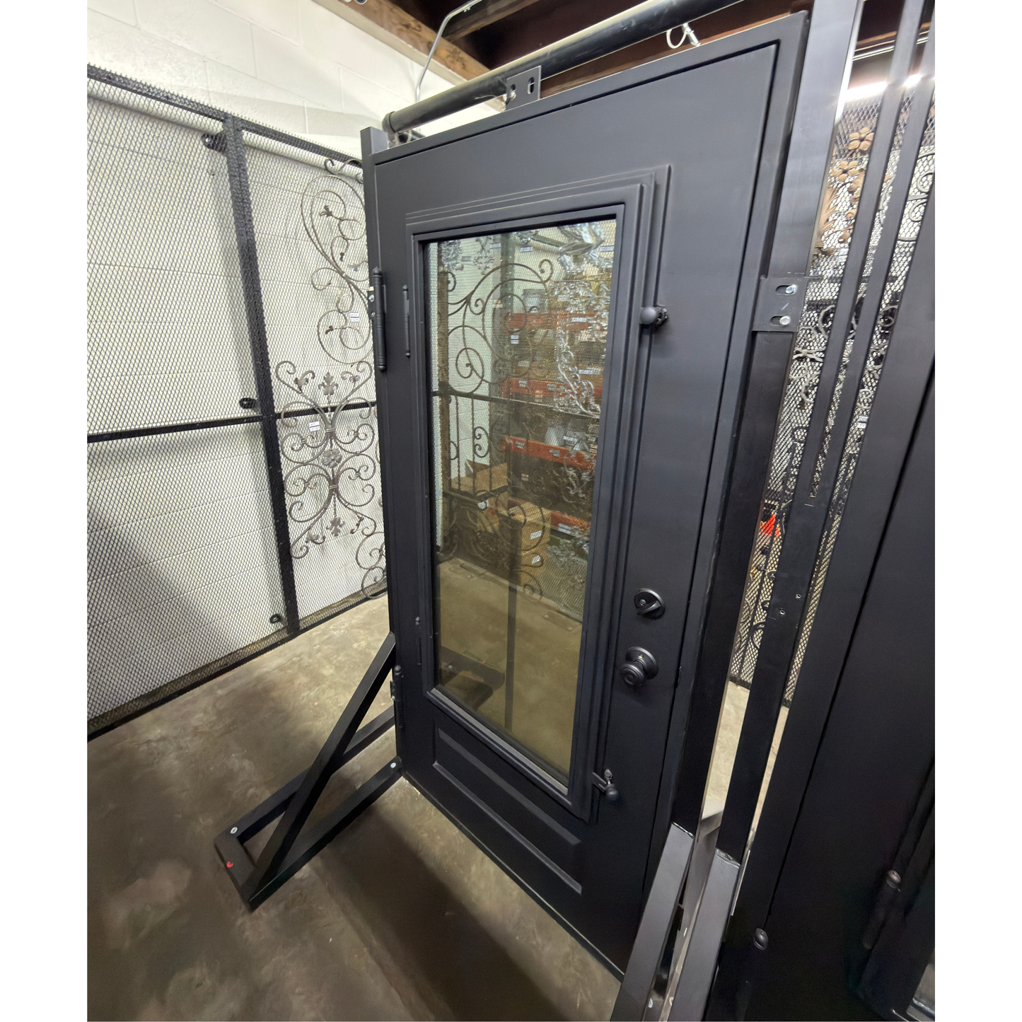 Black metal door with glass panel on display 