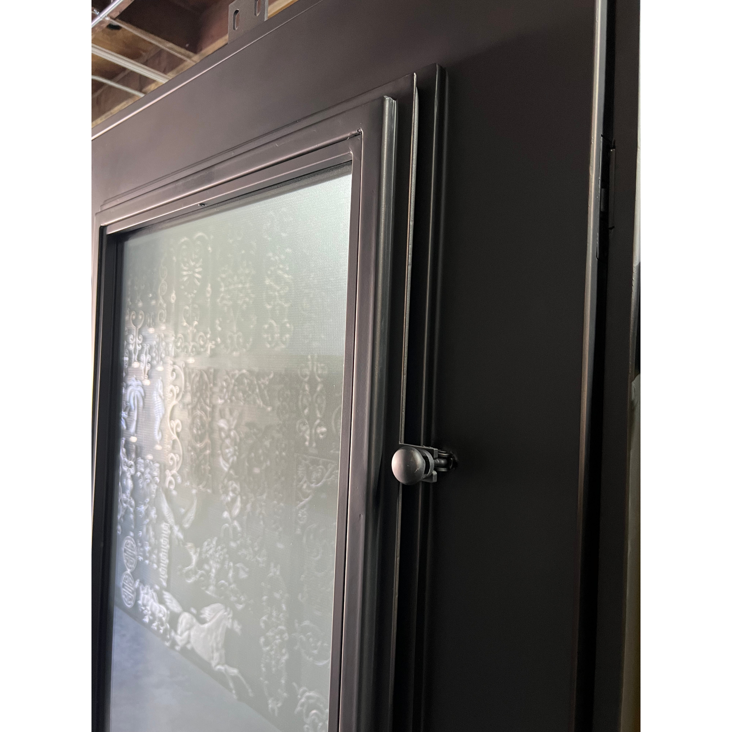 Close-up of a black door with a glass panel and handle