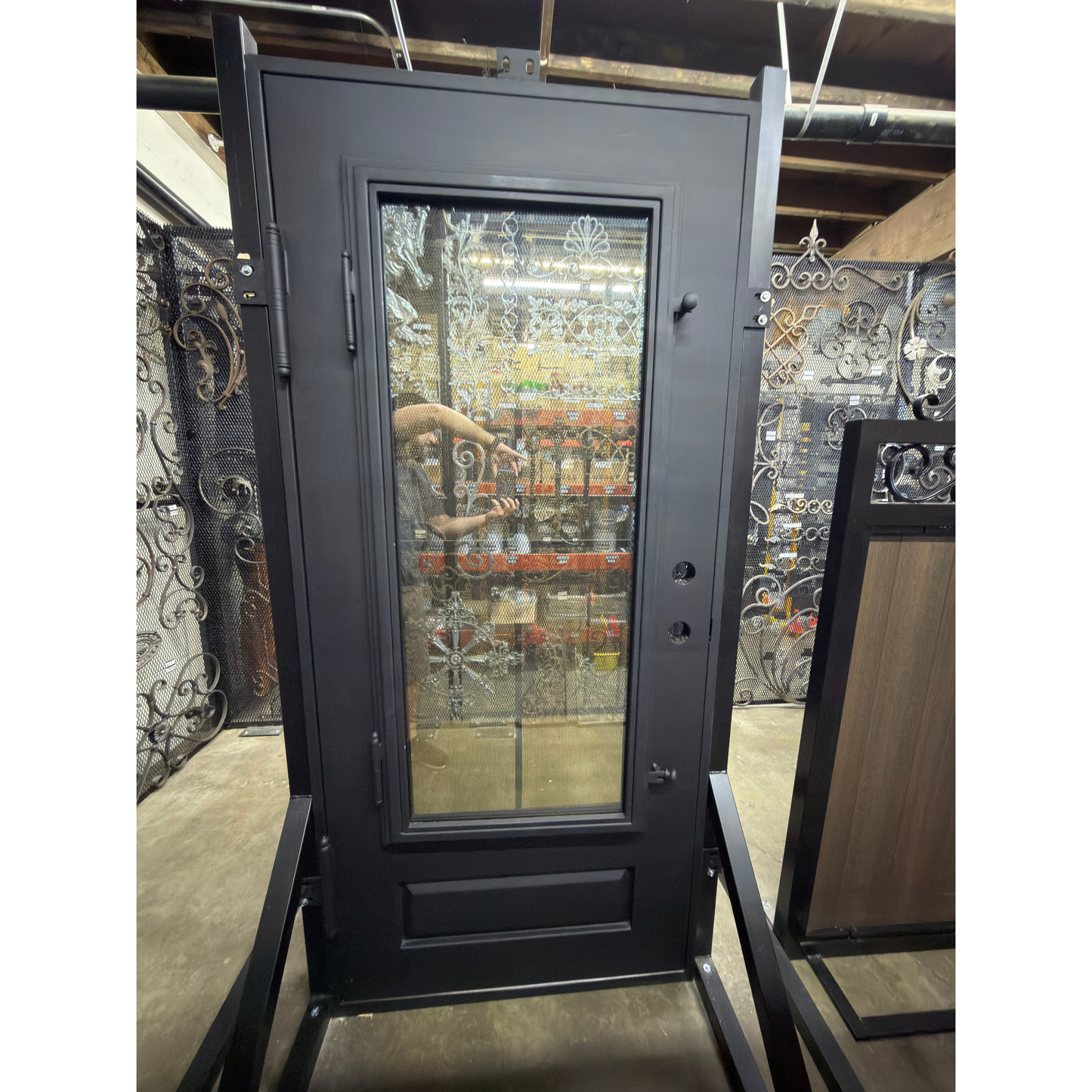 Black metal door with glass panel on a display stand