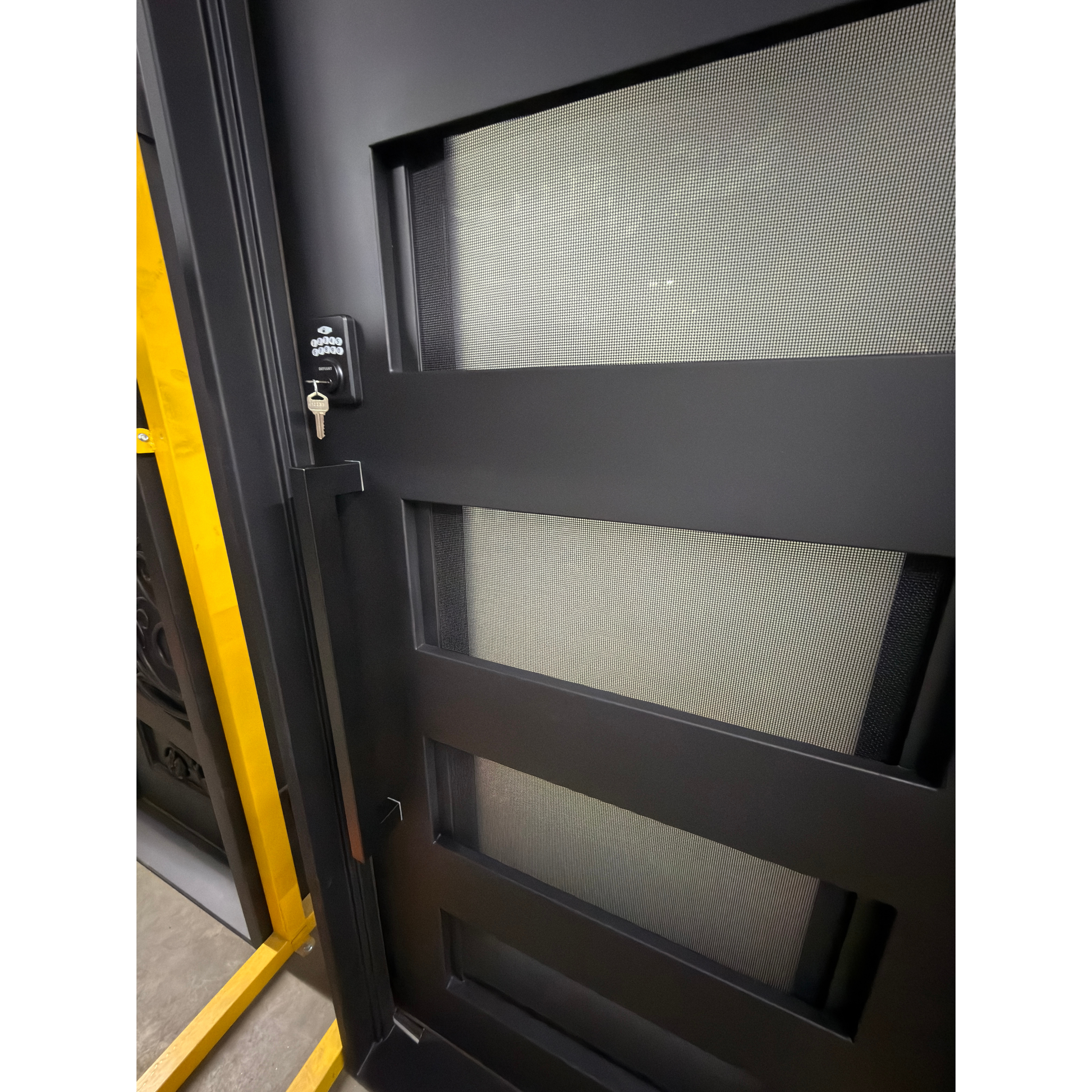 Black sliding screen door with yellow frame and key lock on a white background