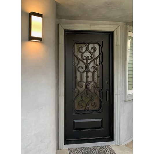 Decorative brown door with intricate iron work on a light-colored wall.