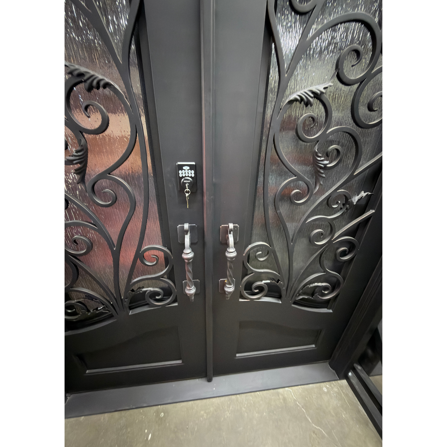 Decorative wrought iron double doors with intricate designs on a white background