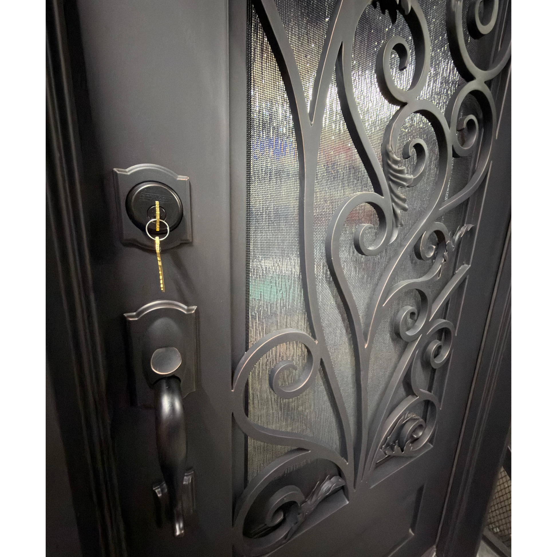 Decorative metal door with intricate designs and a key lock mechanism.
